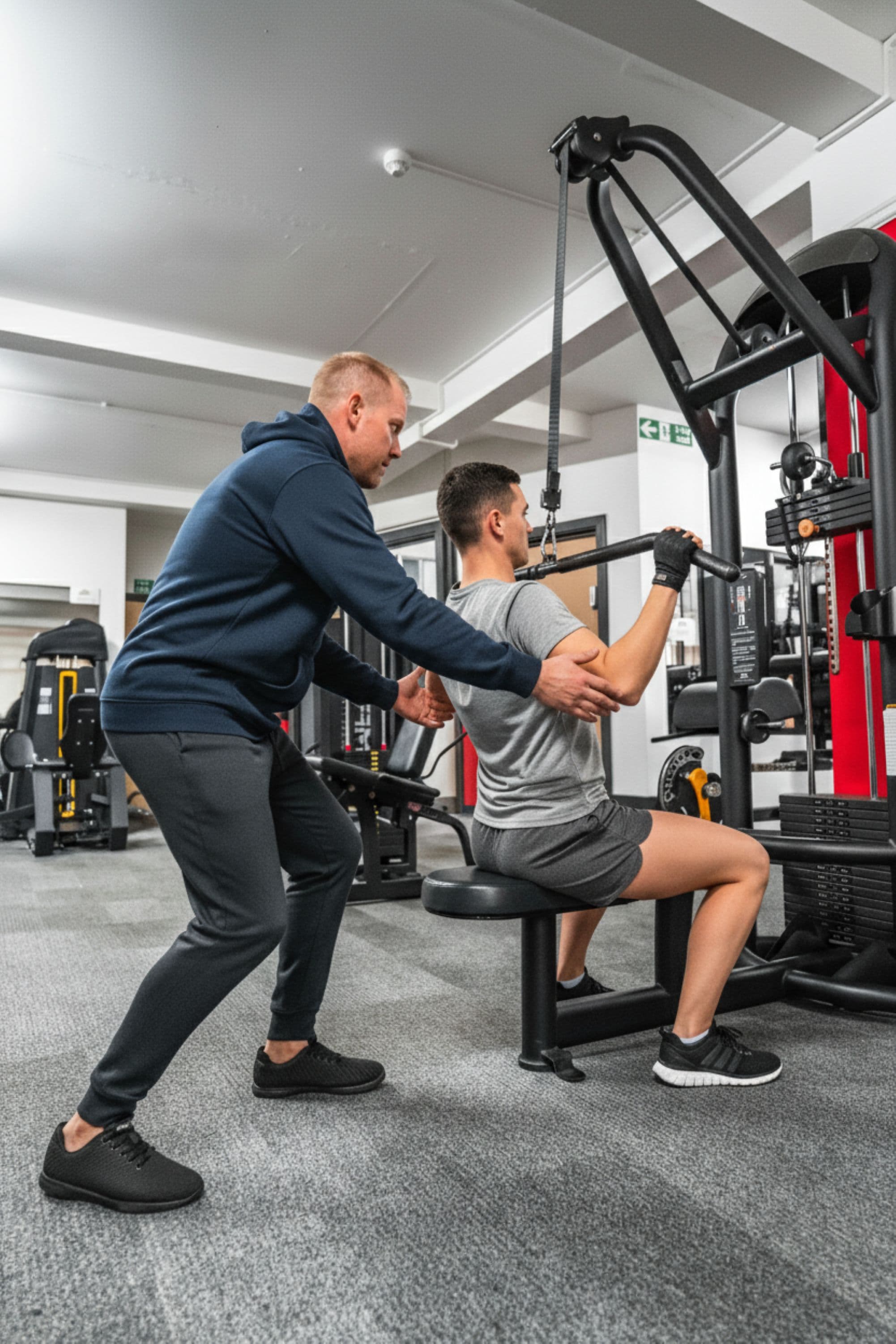 Your personal trainer coaching a client through a resistance machine